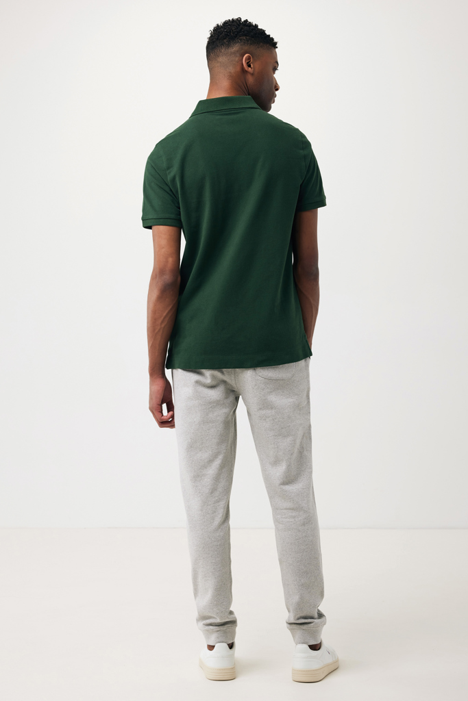 Homme portant polo vert et pantalon gris clair