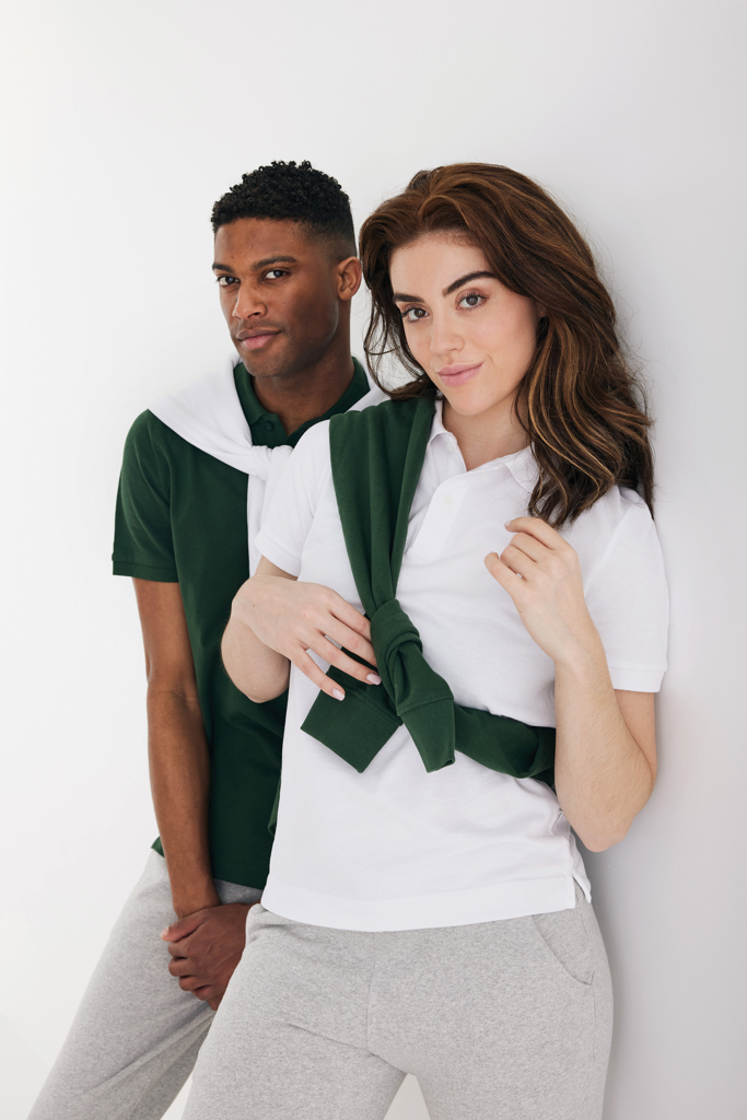 Deux personnes portant des polos verts et blancs.