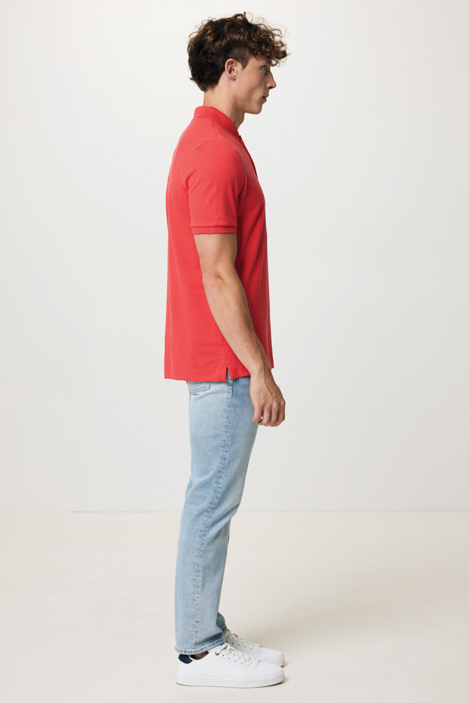 Homme portant polo rouge et jean clair