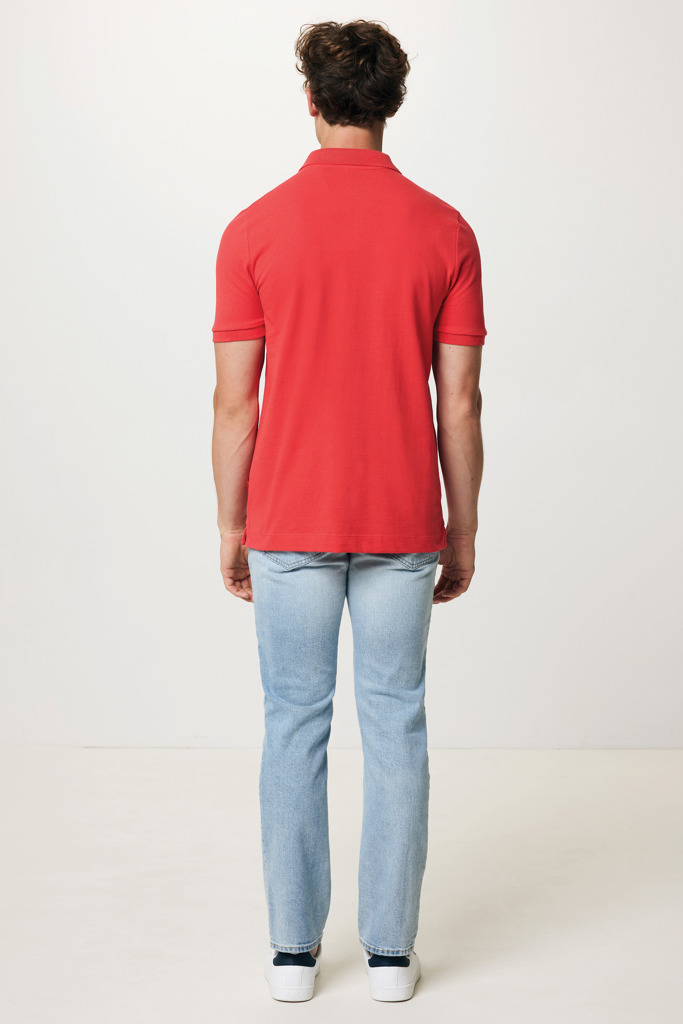 Homme portant polo rouge et jean clair