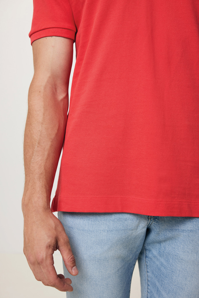 Homme portant polo rouge et jean clair