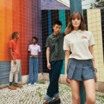 Groupe de jeunes posant devant mur coloré.