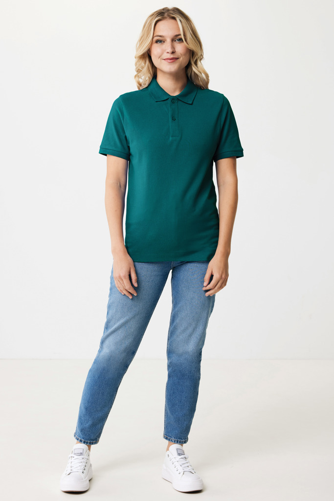 Femme portant un polo vert et jean bleu.
