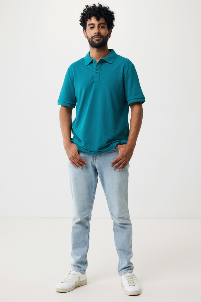 Homme portant polo turquoise et jean clair