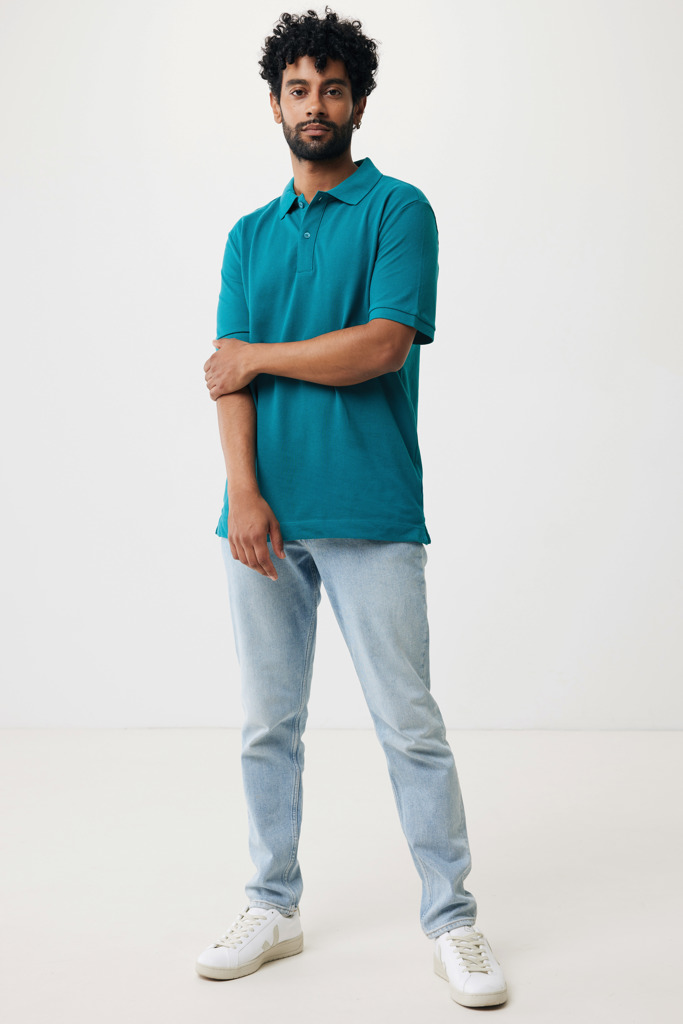 Homme portant polo turquoise et jean clair
