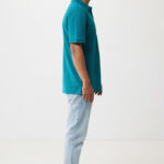Homme portant polo turquoise et jean clair.