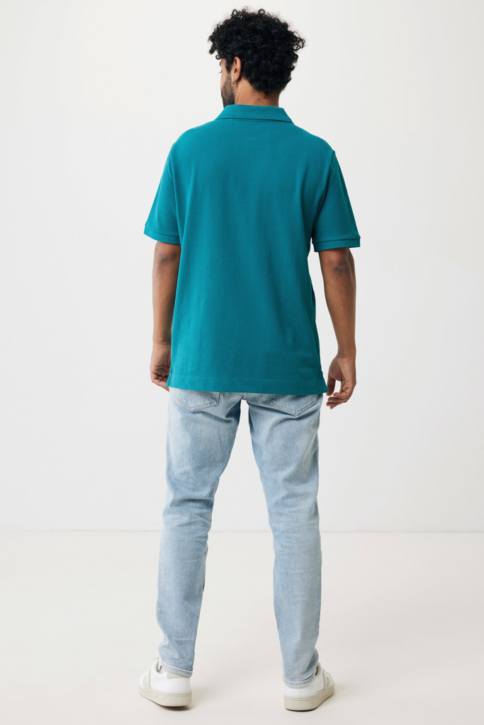 Homme portant polo turquoise et jean clair