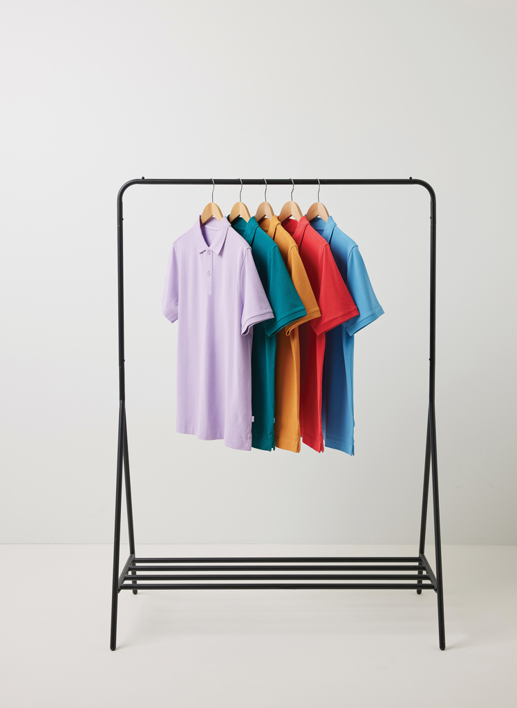 Polos colorés suspendus sur un portant noir