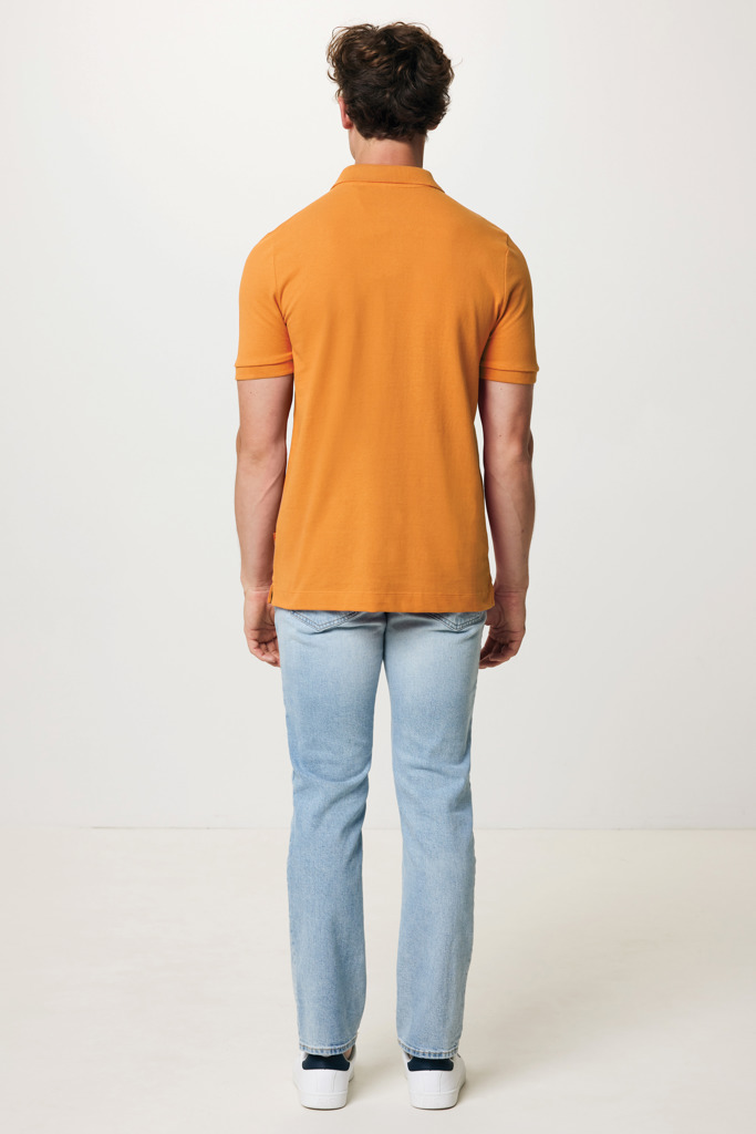 Homme de dos portant polo orange et jean clair