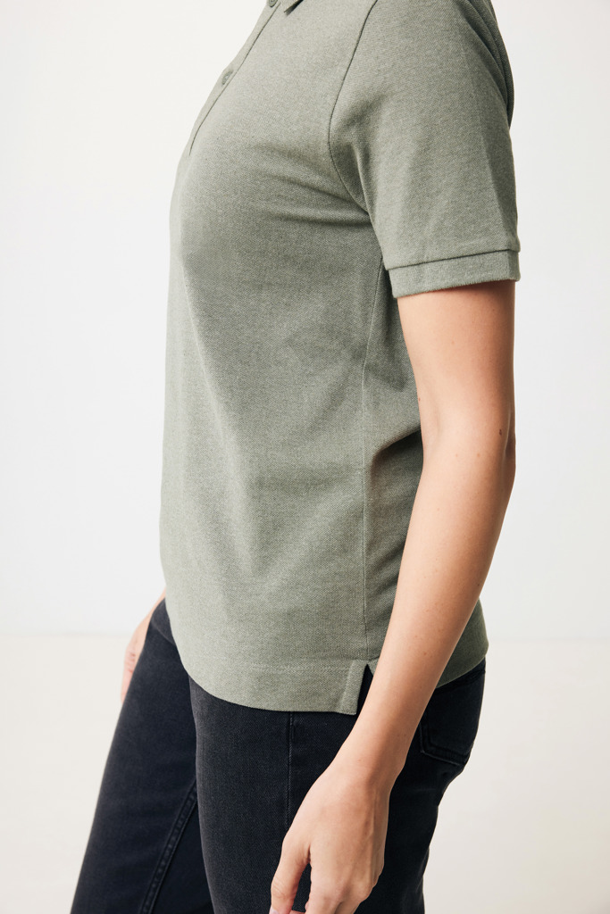 Femme portant un polo vert et un jean noir
