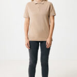 Femme portant un polo beige et jean noir