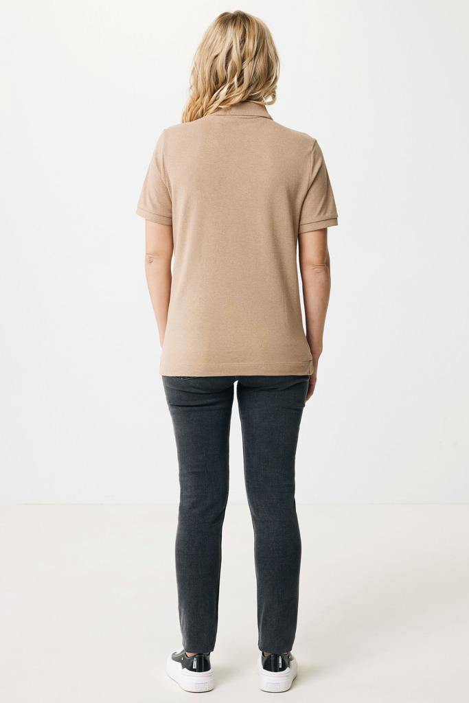 Femme portant polo beige et jean noir.