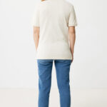 Femme portant un polo beige et jean bleu.