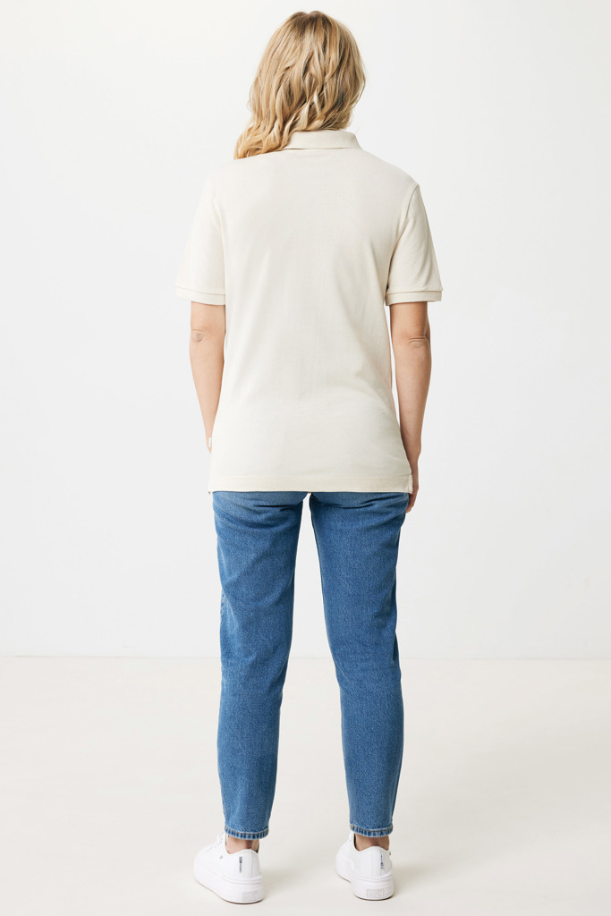 Femme portant un polo beige et jean bleu.