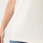 Personne portant un t-shirt beige et un jean bleu