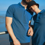 Couple portant des polos bleus au bord de mer