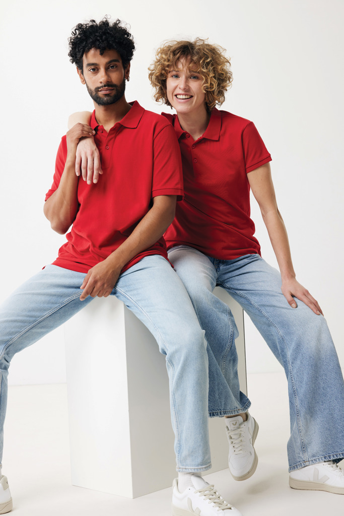 Deux personnes portent polos rouges et jeans clairs.
