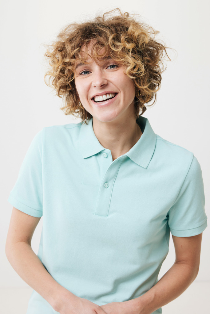 Personne souriante portant un polo bleu clair