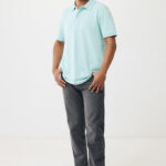 Homme portant polo bleu clair et jean gris.