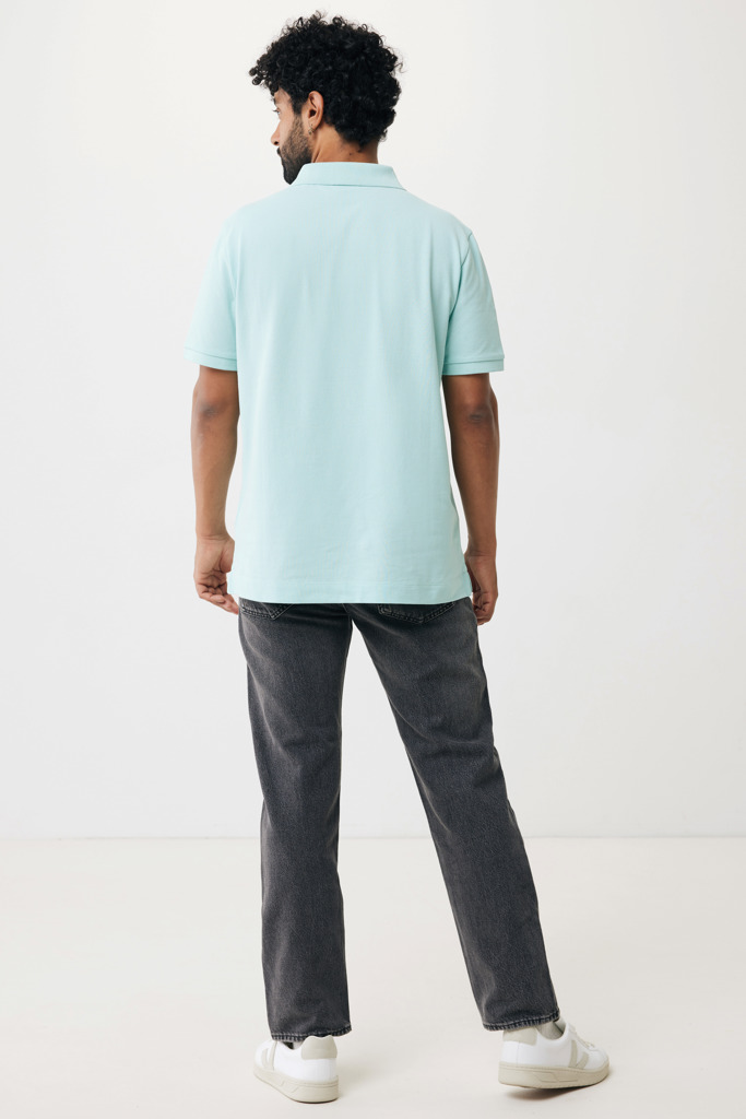 Homme portant polo bleu et jean gris