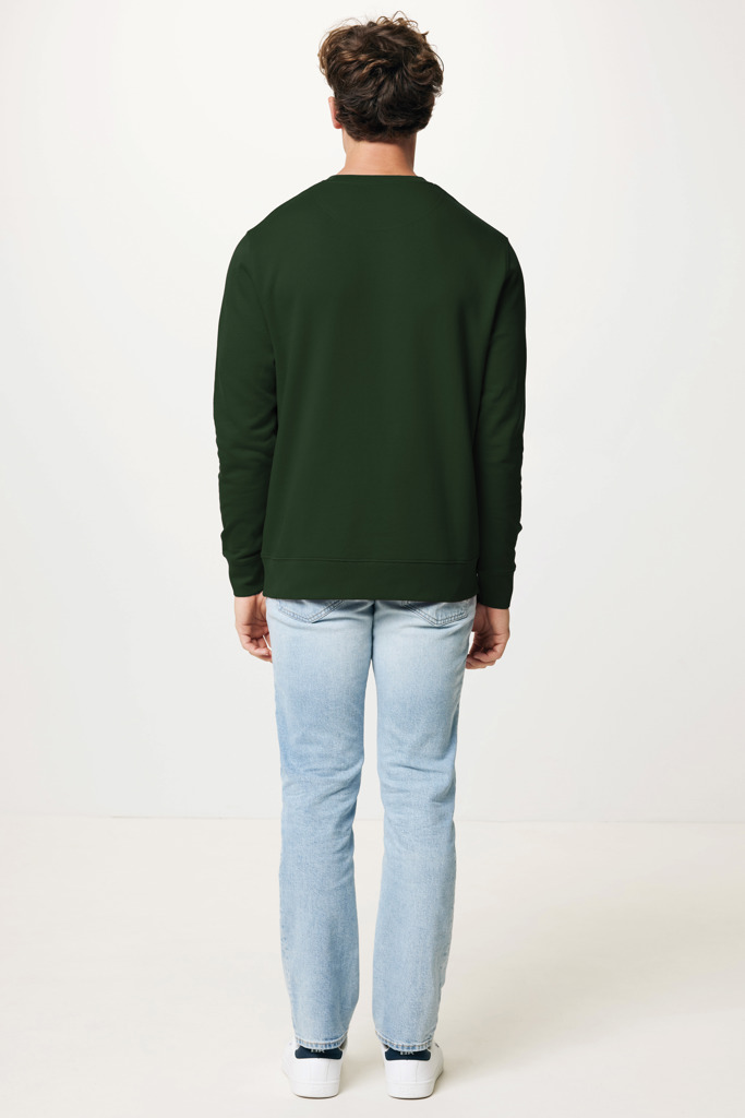 Homme portant un sweat vert et jean clair.