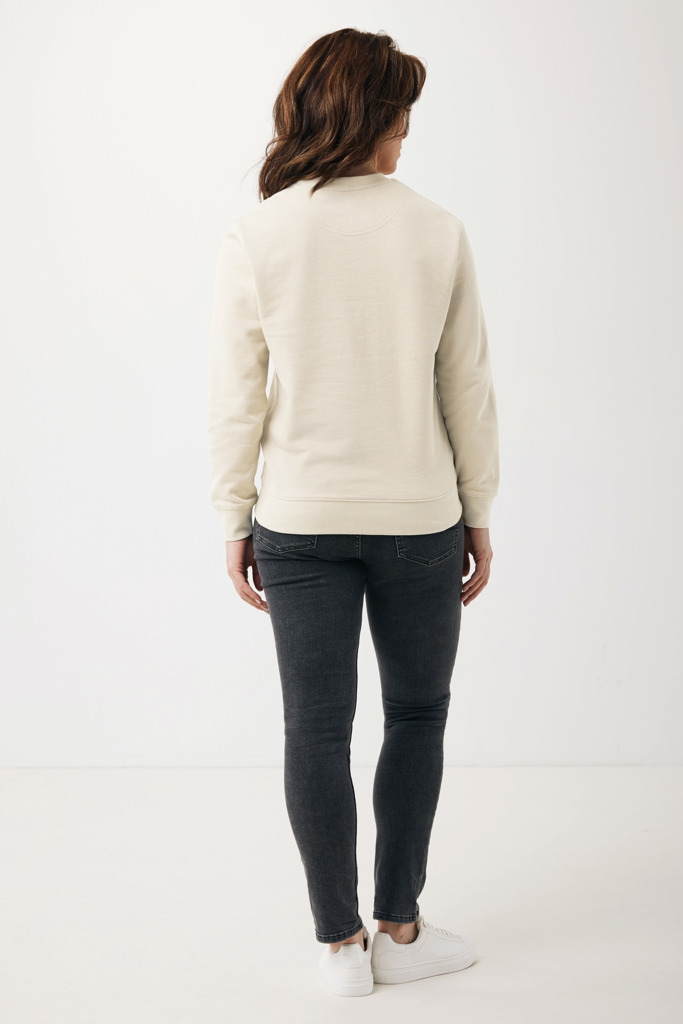 Femme portant jean noir et sweat beige.