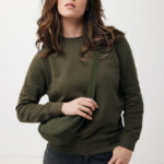 Femme portant un sweat vert et sac banane