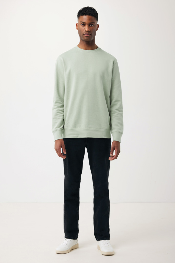 Homme portant pull vert clair et pantalon noir