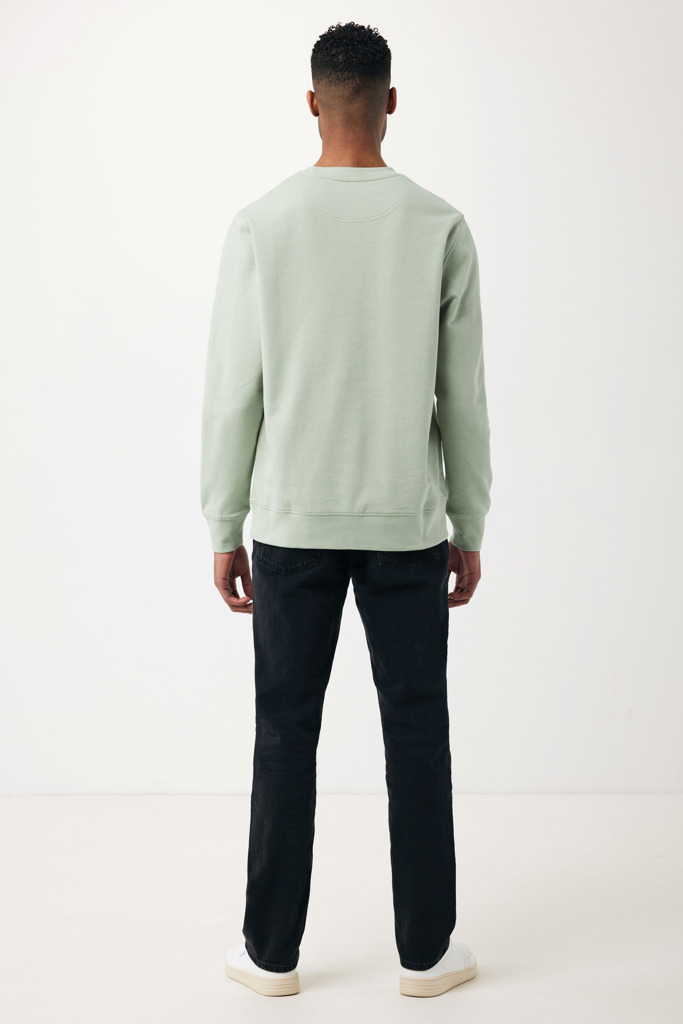 Homme portant un sweat vert et un jean noir