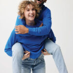 Couple joyeux en sweat bleu, séance photo ludique