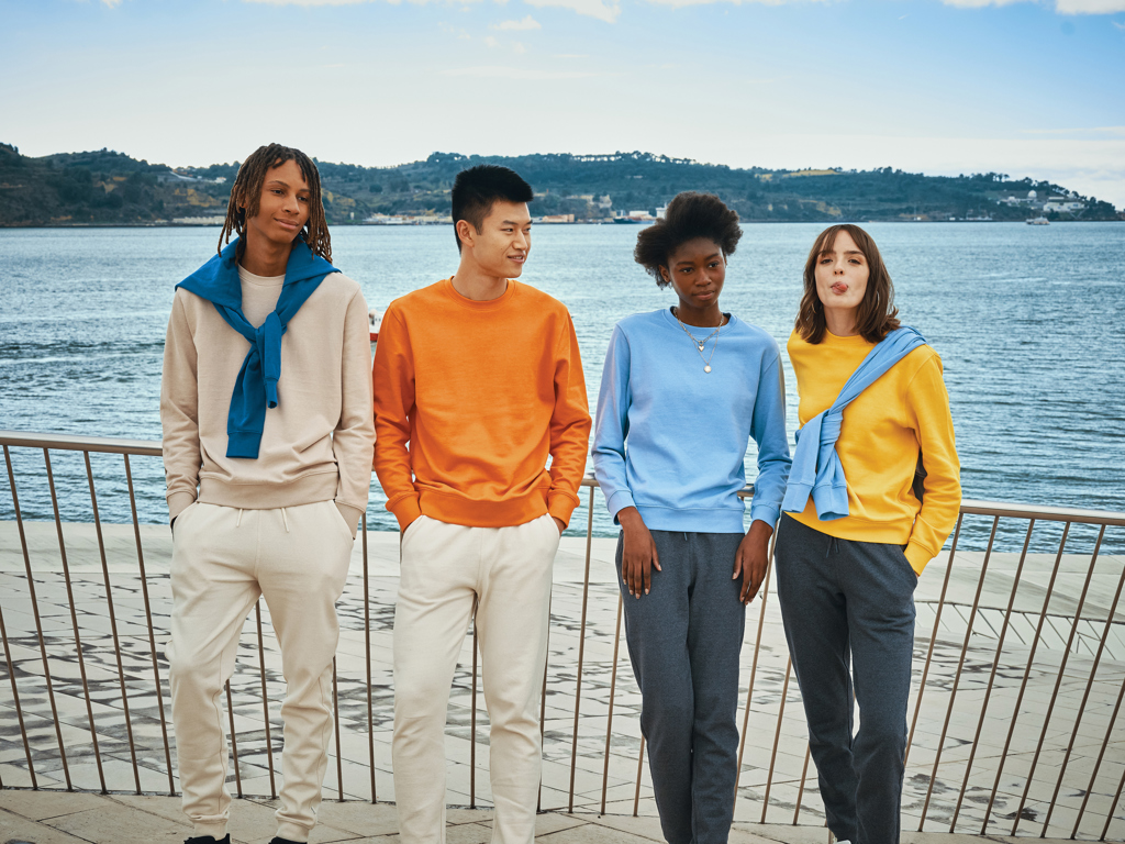 Groupe de jeunes en sweat-shirts colorés près de l’eau