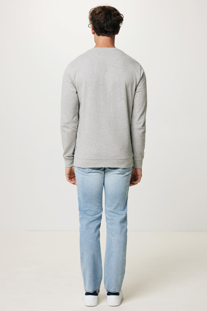 Homme portant un jean clair et sweat gris.