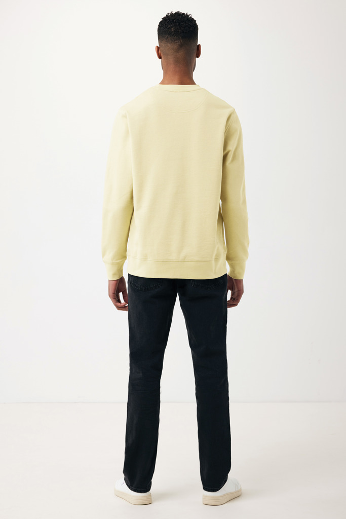 Homme portant un sweat beige et jean noir