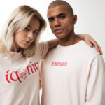 Couple portant des t-shirts beiges avec textes rouges.