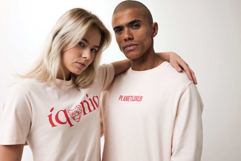 Couple portant des t-shirts beiges avec textes rouges.