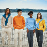 Groupe d’amis en sweats colorés près de la mer