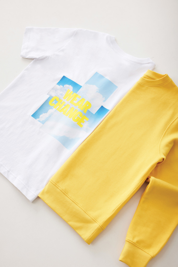 T-shirt blanc et sweat jaune posés côte à côte.