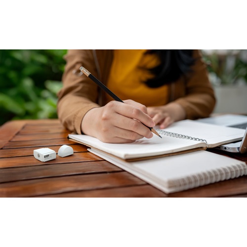 Personne écrivant dans un carnet sur une table