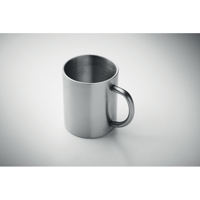 Tasse en acier inoxydable sur fond gris.