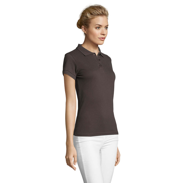 Femme portant polo marron et pantalon clair