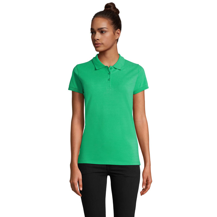 Femme portant polo vert et pantalon noir