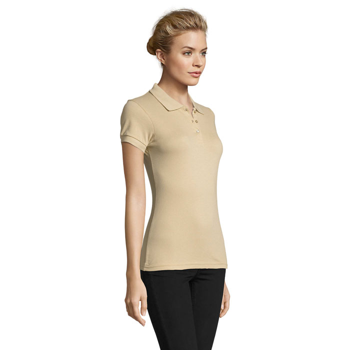 Femme portant polo beige et pantalon noir