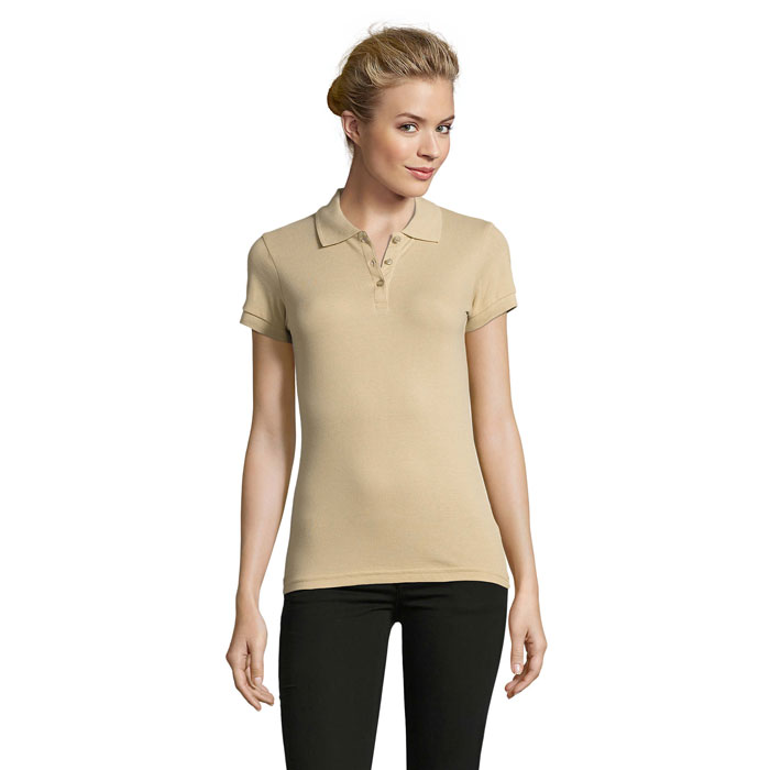 Femme portant polo beige et pantalon noir