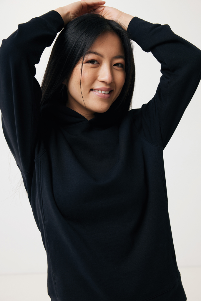 Femme souriante en sweat noir, bras levés