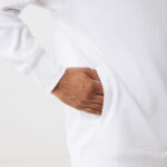 Main dans la poche d’un sweat blanc