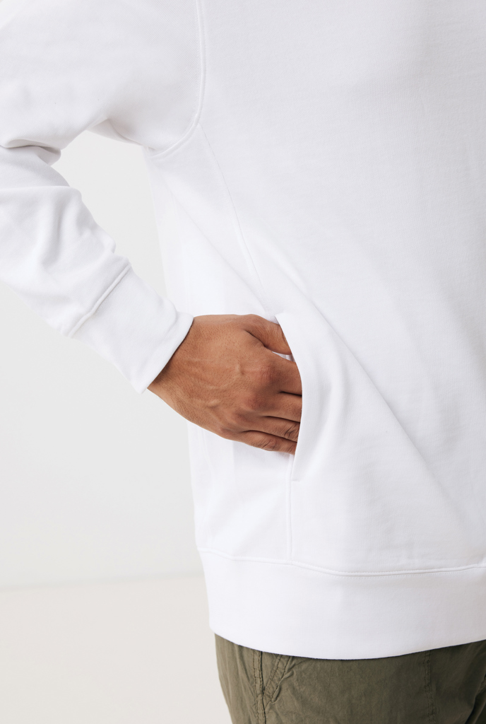 Main dans la poche d’un sweat blanc