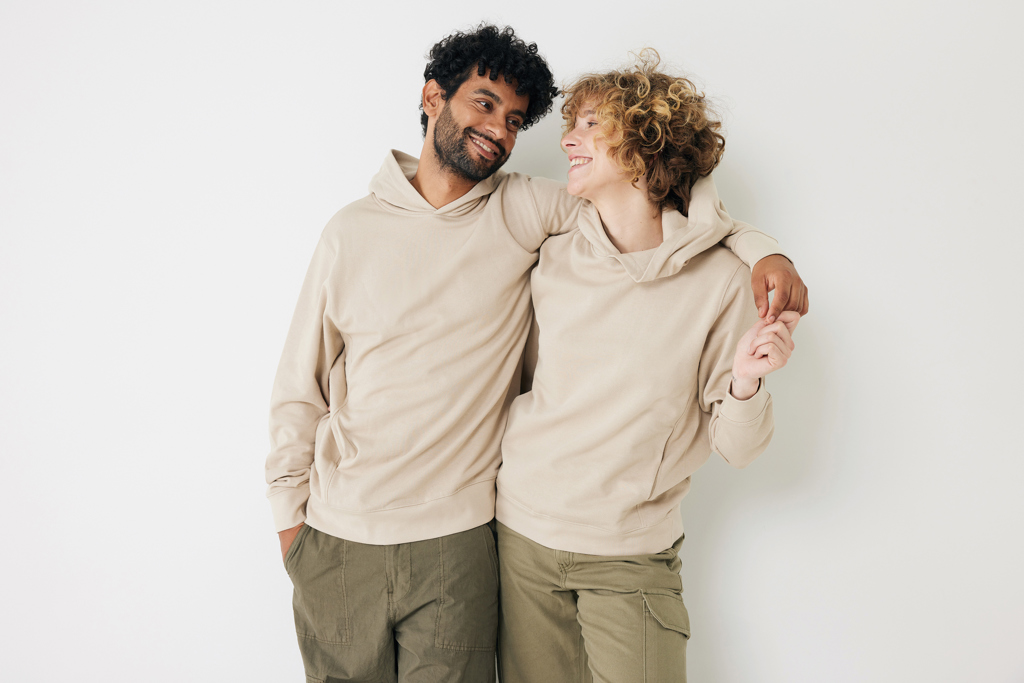 Couple souriant en sweats beiges, fond neutre
