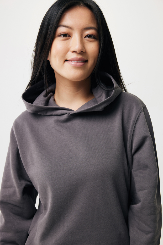 Femme souriante portant un sweat à capuche gris