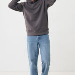 Homme portant sweat à capuche gris et jean