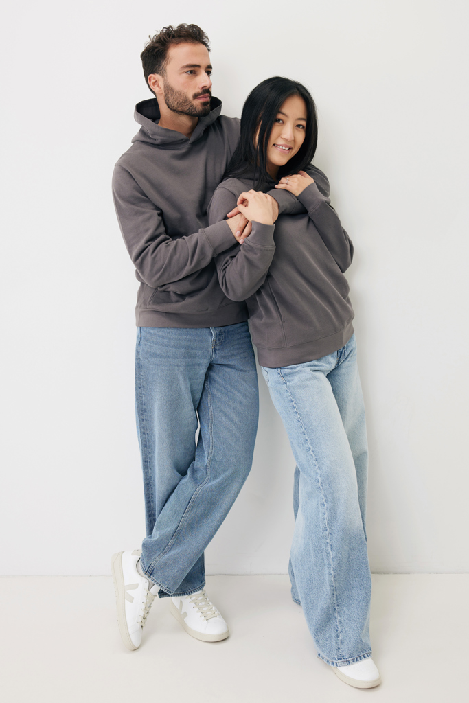 Couple en sweats gris contre un mur